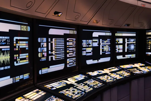 A high-tech command center with illuminated digital screens in a futuristic setting. Hvilke moduler bør et HR-system indeholde?