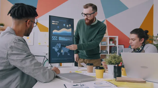 Team collaboration on business growth strategy with data charts in a modern office. Rekrutteringsprocessen: Fra behovsafdækning til ansættelse